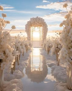 an outdoor ceremony with white flowers in vases and the sun shining through the clouds