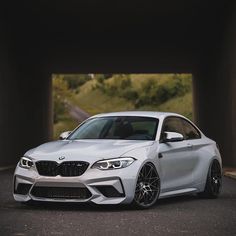 a white car parked in front of a tunnel