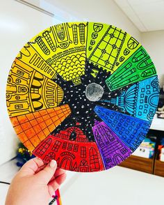 a person holding up a colorful wheel of colors