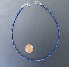 A minimalist necklace made with rich blue beads of genuine lapis lazuli. These AAA quality stones measure 2mm in diameter, and they are round with multifaceted cuts that give them a little extra shimmer in the light. There is a small silver bead at each end, and this connects with a sterling silver lobster claw clasp in the back. Available in a variety of lengths, and comes packaged in a small gift box for you. Ships in 1 business day, via USPS ground advantage. Lapis Lazuli Necklace With Faceted Beads, Blue Lapis Lazuli Crystal Necklaces With Faceted Beads, Round Lapis Lazuli Necklace With Faceted Beads, Blue Lapis Lazuli Crystal Necklace With Faceted Beads, Faceted Sapphire Round Bead Necklaces, Sapphire Necklaces With Faceted Round Beads, Blue Faceted Lapis Lazuli Beaded Necklaces, Blue Faceted Lapis Lazuli Beaded Necklace, Faceted Blue Lapis Lazuli Necklace