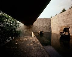 there are two boats on the water in this pool and one is under a bridge