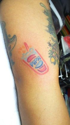 a person with a tattoo on their arm has a toothbrush in the shape of a cup