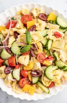 a white bowl filled with pasta and vegetables