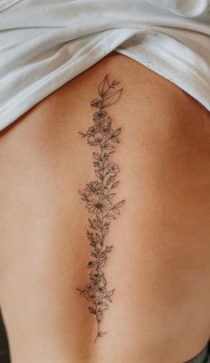 a woman's lower back tattoo with flowers on it