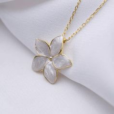 The Blossom Serenity Flower necklace is inspired by the delicate balance of nature's beauty and minimalist design. Crafted with precision, this exquisite necklace features a stunning 18K gold and 925 sterling silver flower pendant, adorned with a radiant Mother of Pearl stone at its center.  Every piece is meticulously handcrafted, ensuring each necklace is as unique as the woman who wears it. Whether you're dressing up for a special occasion or adding a touch of elegance to your daily ensemble, Delicate White Gold Flower Pendant Necklace, Dainty White Gold Flower Necklace, Delicate White Necklace For Mom, Elegant White Flower Necklace With Birth Flower Detail, Elegant White Flower Necklace For Birth Month, Elegant White Flower Necklace For Birthdays, Elegant White Birth Flower Necklace, Minimalist Sterling Silver Flower Necklace, White Sterling Silver Flower Necklace For Mother's Day