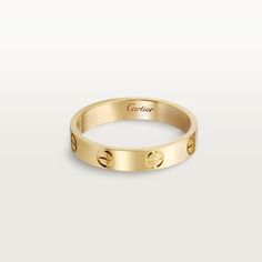 an 18k yellow gold ring with screws on the outside, and two small round holes in the middle