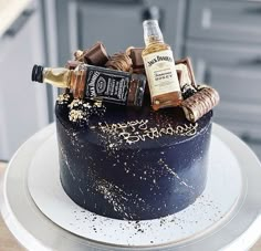 there is a chocolate cake with liquor bottles on it and gold sprinkles