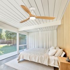 a bedroom with white walls and ceiling fans