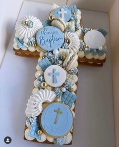 a decorated cookie cross on top of a white countertop with blue and gold decorations