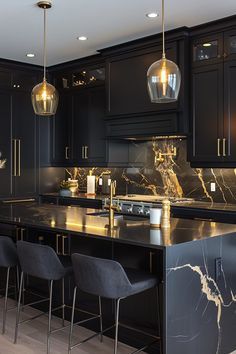 a kitchen with black cabinets and marble counter tops, bar stools and pendant lights