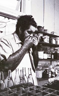 a man standing in front of a counter covered in bottles