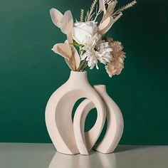 there is a white vase with flowers in it