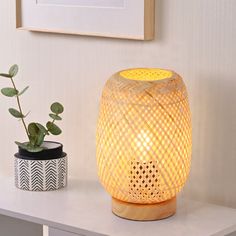 a white table with a yellow light next to a potted plant