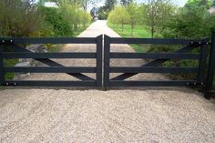 an open gate leading to a dirt road