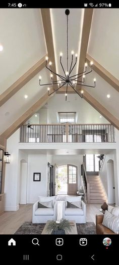 a living room filled with furniture and a chandelier hanging from the top of it