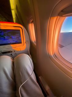 the view from inside an airplane looking out at the wing and window with someone's feet propped up in front of them