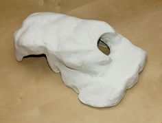 a white sculpture sitting on top of a wooden table