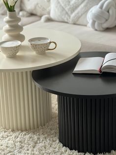 a coffee table with a book and two cups on it