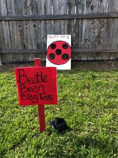 a sign in the grass that says beette bean pegs and another sign with a ladybug on it