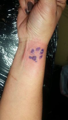 a woman's arm with a purple paw print on it