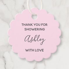 a pink thank you for showering with love ornament on a marble background