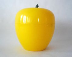 a yellow apple sitting on top of a white table