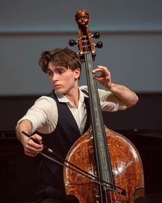 a young man is playing the cello