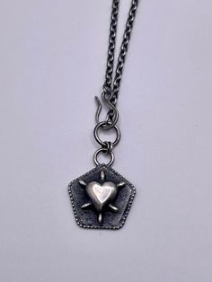 Handmade in recycled sterling silver this gothic design Medallion necklace was made using a combination of techniques including sand casting, fusion and oxidisation (black patina). Complete with satin finish which perfectly highlights the raised spiked heart design.  30mm drop x 19mm width Suspended from chunky 17inch belcher chain with a handmade hook & front closure. Hallmarked at London Assay office Artisan Silver Necklace With Heart Charm, Gothic Necklaces, Hand Forged Silver Heart Jewelry, Silver Hand Forged Heart Necklace, Hand Forged Silver Heart Necklace, Silver Heart Necklace With Oxidized Finish, Handmade Silver Gothic Chain Necklace, Heart Shaped Sterling Silver Necklace With Oxidized Finish, Silver Gothic Heart Necklace