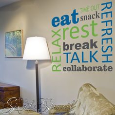 a lamp on a table in front of a wall that has words painted on it