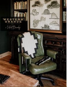 a green chair sitting in front of a book shelf next to a painting on the wall