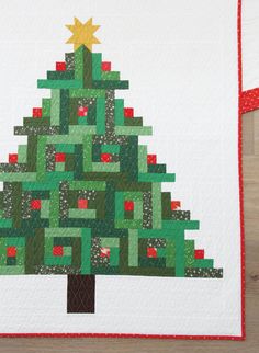 a quilted christmas tree is displayed on a table