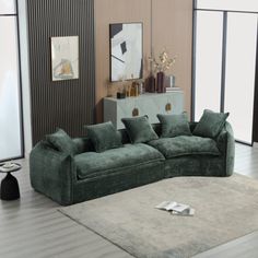 a living room with a large green couch and white rug on the hardwood flooring