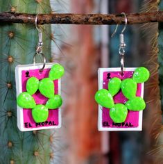 green and pink earrings hanging from a cactus plant with the words el mohair on it