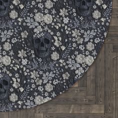 a black and white rug with skulls, flowers and leaves on the floor in front of a wood paneled wall