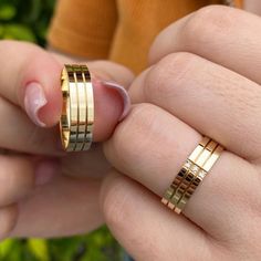 two people holding gold rings in their hands