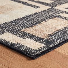 a black and white rug on top of a wooden floor