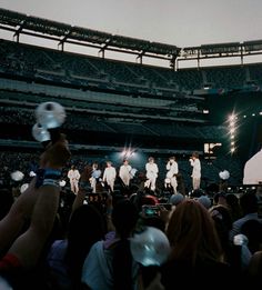 a group of people standing on top of a stage in front of a large crowd