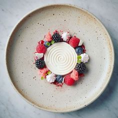 a white plate topped with berries, raspberries and other fruit on top of it