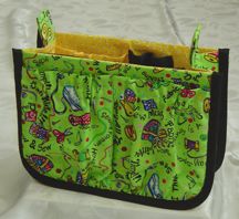 a green and black purse sitting on top of a bed