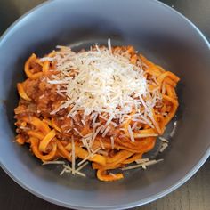 a blue bowl filled with pasta and cheese