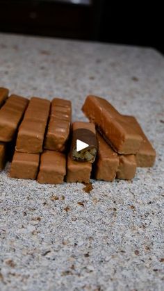 a pile of chocolate bars sitting on top of a counter next to a piece of candy