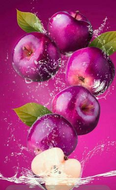 purple apples are falling into the water with leaves on their tops and in the air