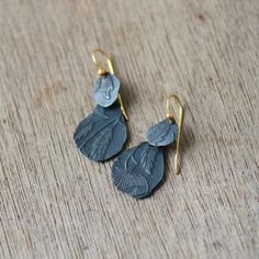 From the Keepsake collection - an ode to natural treasures; leaves, pebble & rock we often take home as gifts from the landscape. A unique ready-made pair in darkened/oxidised Sterling solid Silver 925 and ear wires in plated in 18kt Gold aka 'Vermeil'. 2 small leaf-like petals layered on each side upon their own individual pattern, all purposefully made slightly asymmetrical in their form, layered upon layer. Hand-crafted pair-by-pair what you see is what you'll receive. Each pair is different Nature-inspired Dangle Earrings, Nature-inspired Leaf-shaped Jewelry With Matching Earrings, Nature-inspired Leaf-shaped Brass Jewelry, Hand Forged Nature-inspired Drop Earrings, Botanical Style Jewelry With Matching Dangle Earrings, Hand Forged Nature-inspired Dangle Jewelry, Nature-inspired Hand Forged Drop Earrings, Botanical Dangle Matching Earrings Jewelry, Hand Forged Teardrop Nature-inspired Jewelry