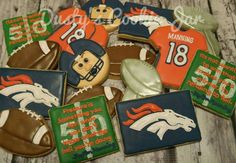 decorated cookies with footballs, helmets and other sports related items are arranged on a wooden surface