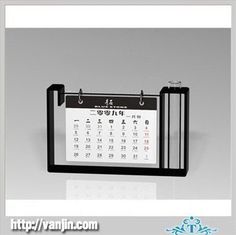 a desk calendar is hanging on the wall in front of a white and gray background