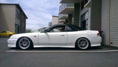 a white sports car parked in front of a building