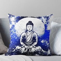 a blue and white buddha throw pillow sitting on top of a couch with the sun behind it