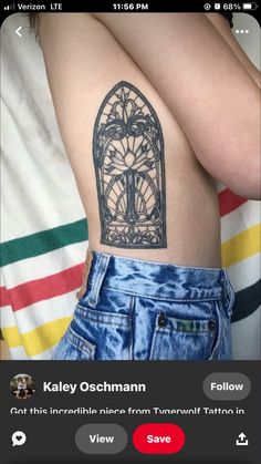 the back of a woman's shoulder with an intricate tattoo on her left arm