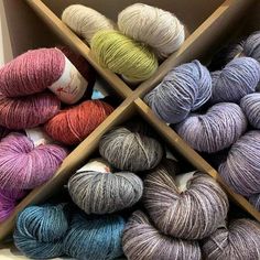 several skeins of yarn are arranged in boxes