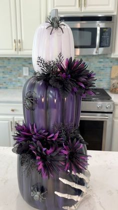 purple and white pumpkins stacked on top of each other in a kitchen with stainless steel appliances